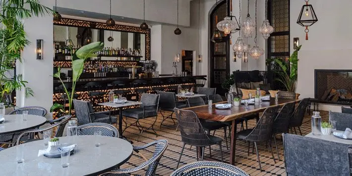 restaurant with tables, chairs, and bar in the background