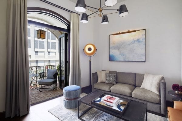 hotel suite living room with furniture and a balcony with chair and table