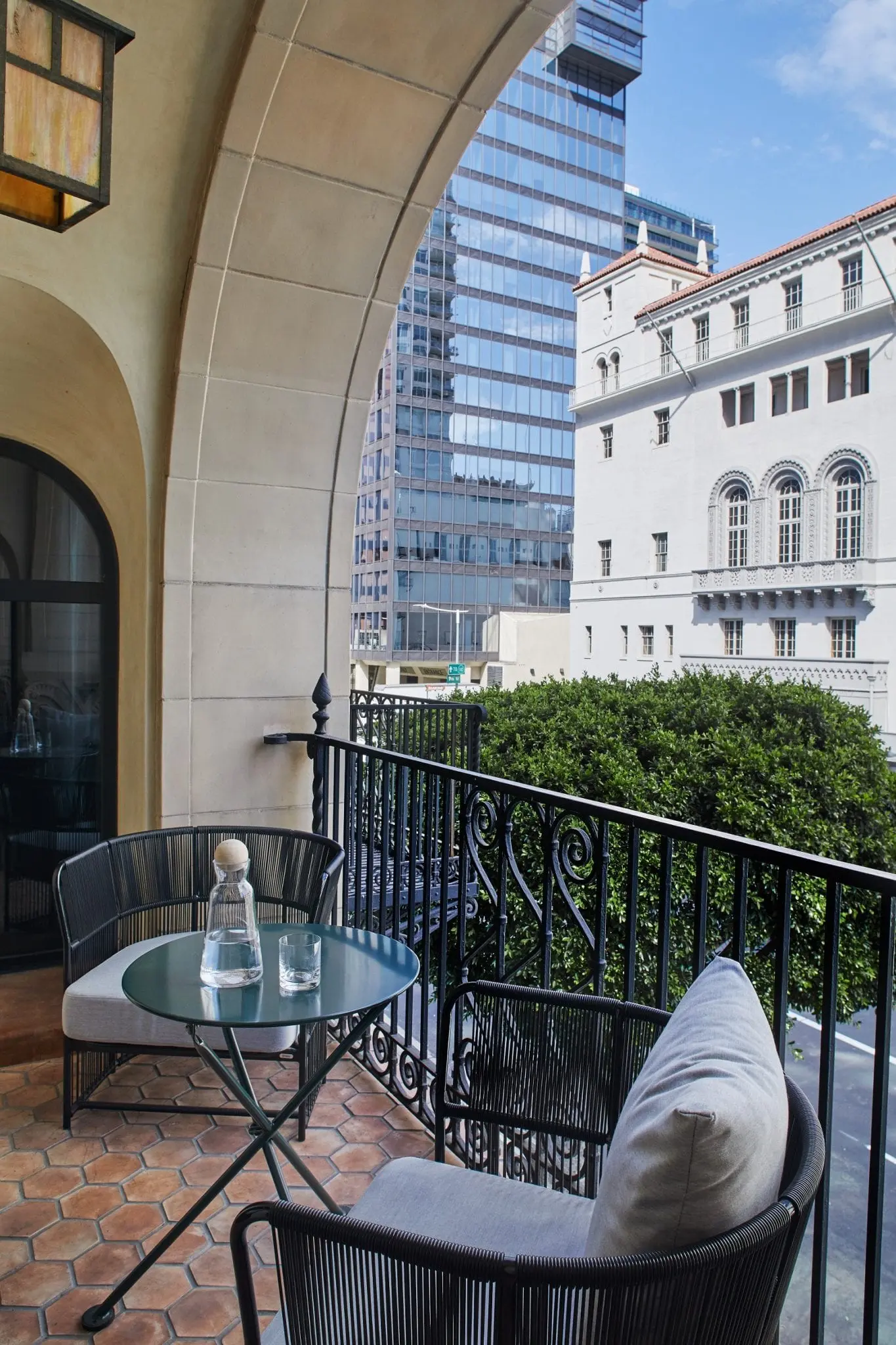 two chairs and a table on a balcony overlooking buildings