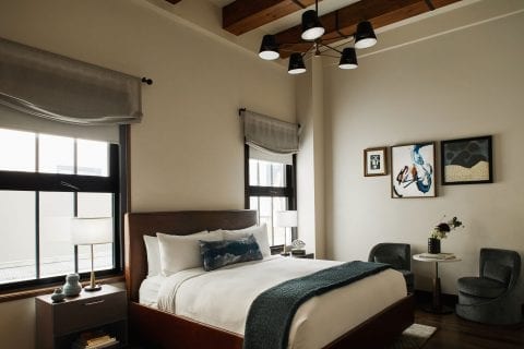 hotel room with bed, nightstands, chairs and a small table