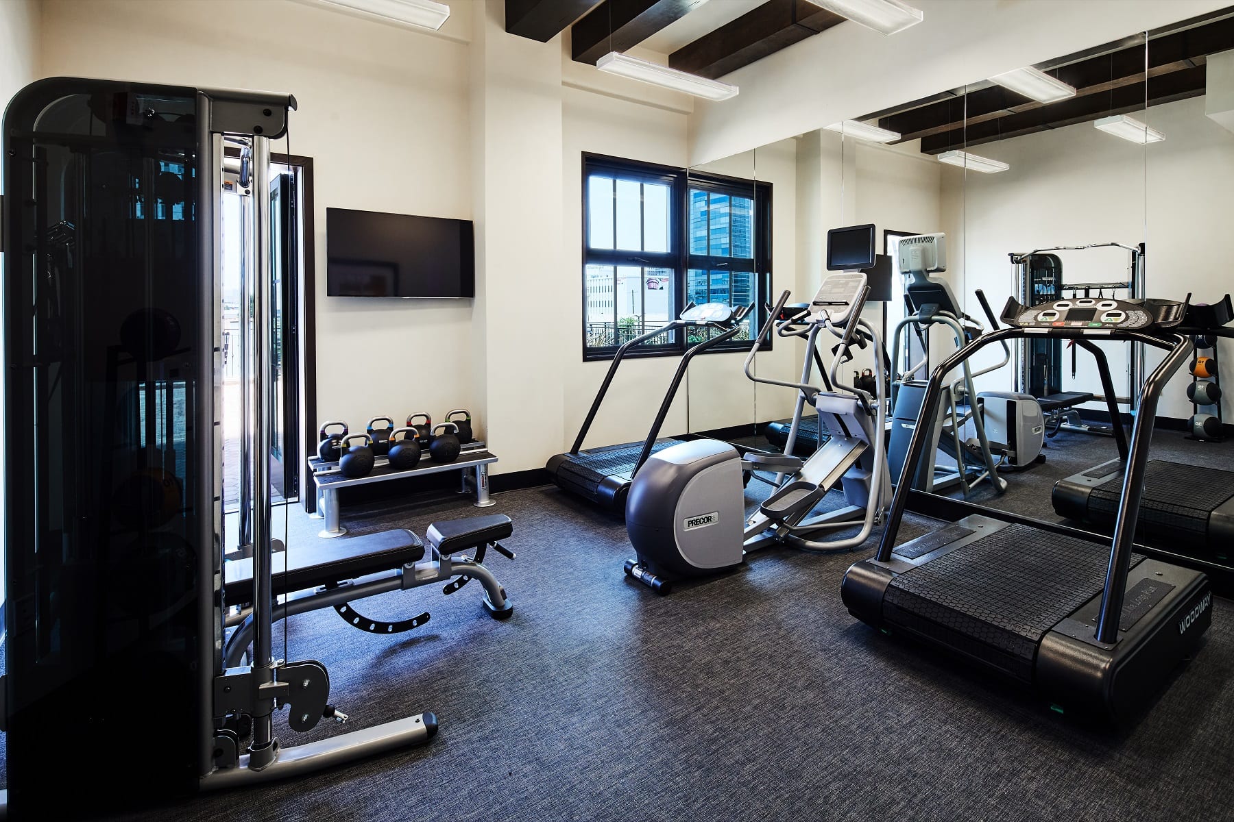 exercise room with treadmill, stationary bikes and weights