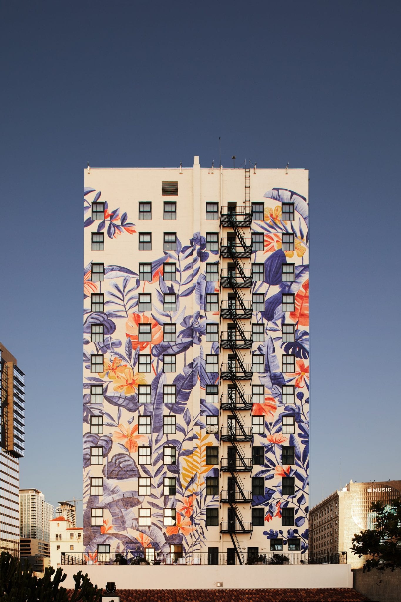 back of a building painted with colorful mural by Bella Gomez