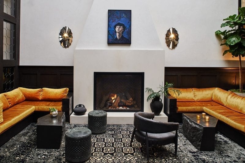 living room with large fireplace with sectional couches at each side, charis and coffee tables