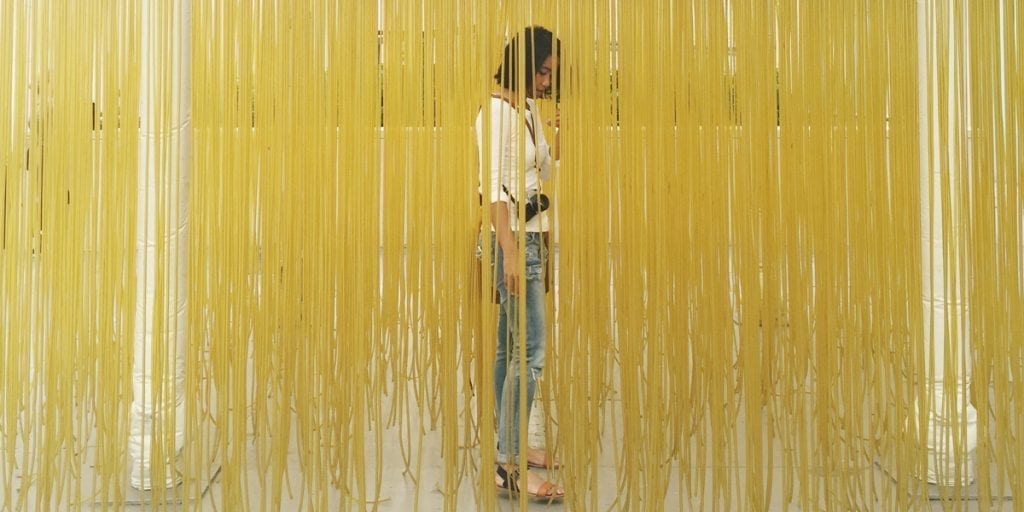 woman standing behind string curtain