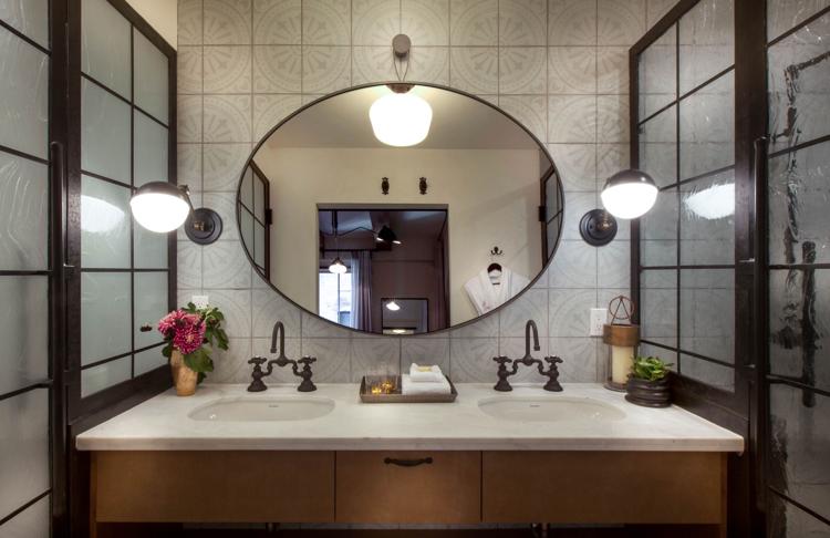 bathroom with dual sinks and large mirror